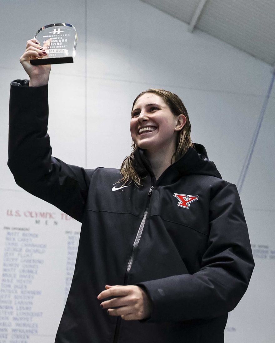 Hannah smiling and holding up her Horizon League championship trophy